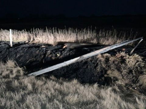 power pole laying in ditch after being hit by car